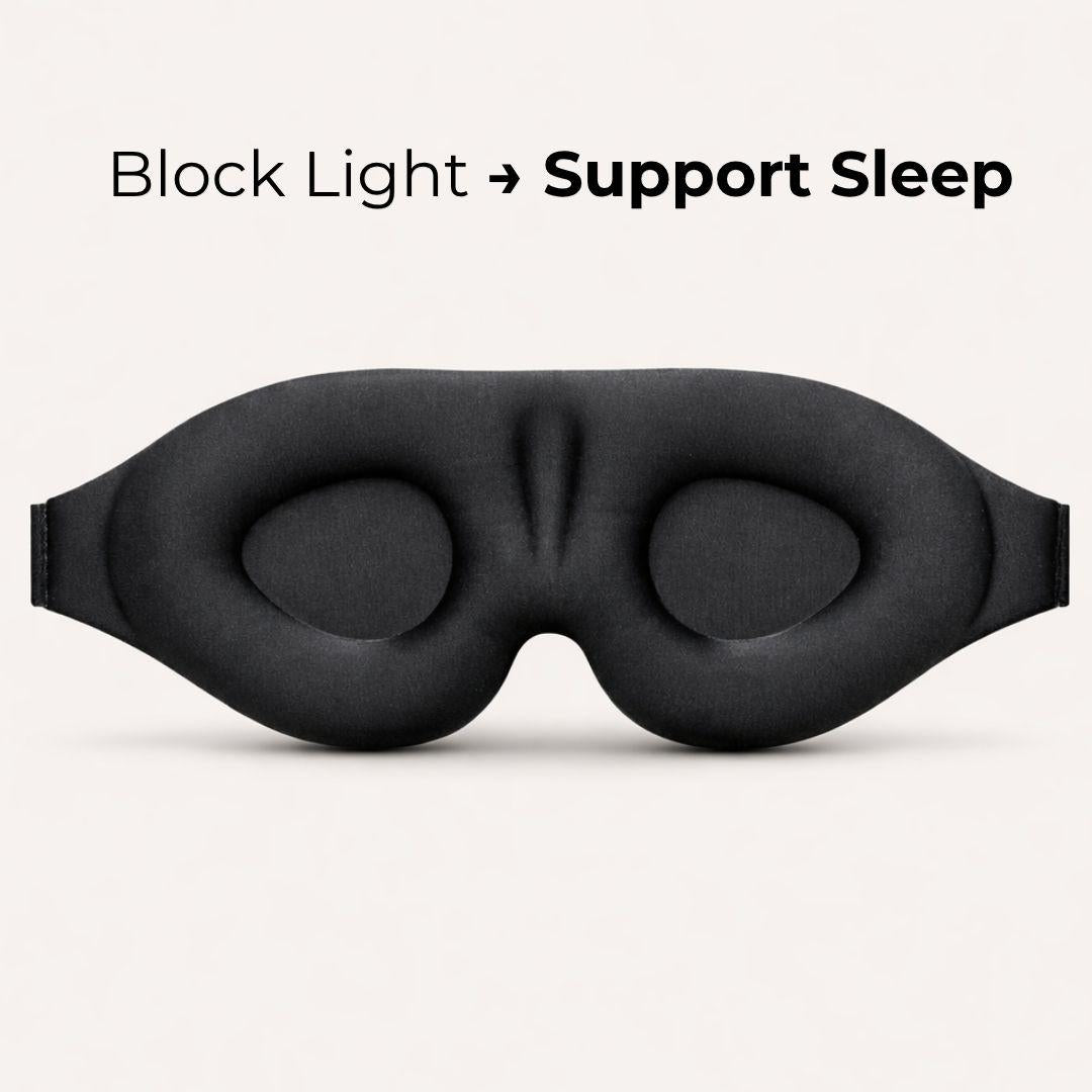 A black eye mask with padded eye cups and a center bridge, shown on a light neutral background with the text 'Block Light -> Support Sleep' above it.